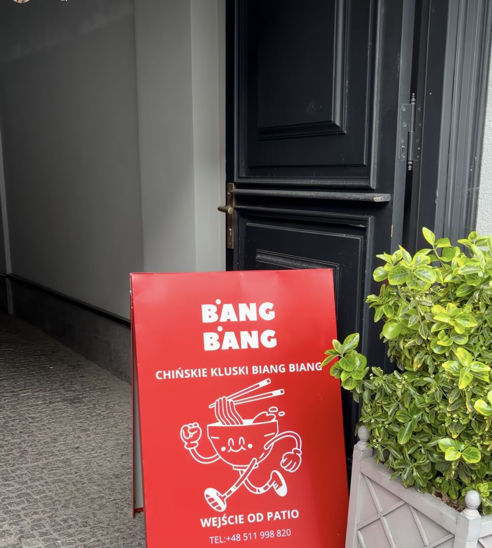 The red BANG BANG A-frame sign at the patio entrance