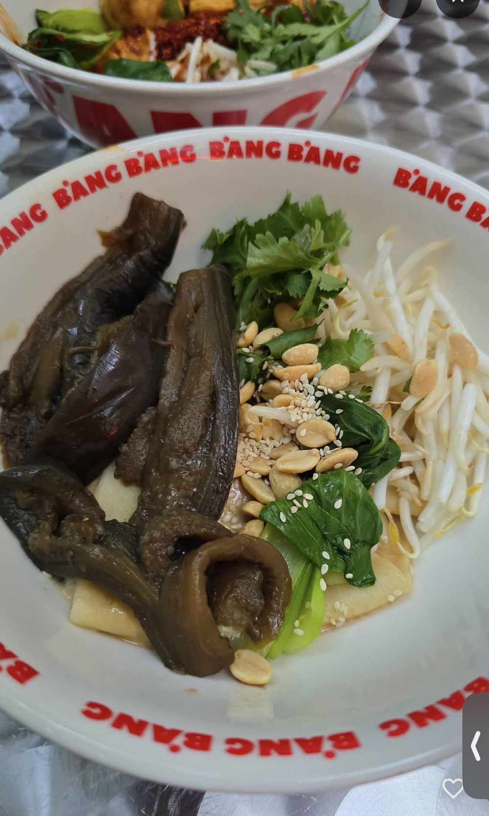 Bowl with braised eggplant, peanuts and pak choi
